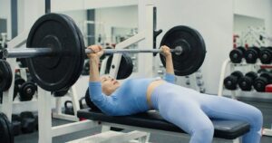 Bench press exercise with head extended into arch position