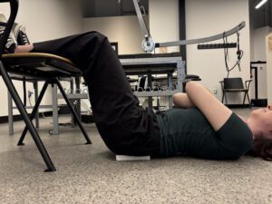Patient performing customized home exercise for anterolisthesis correction based on X-ray findings and spinal biomechanics assessment